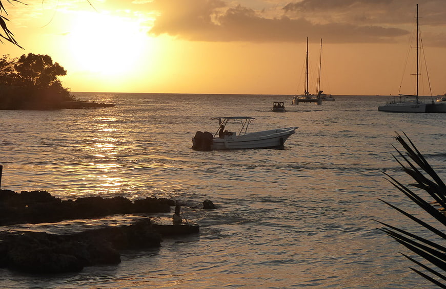 Boats anchored in ocean during golden sunset