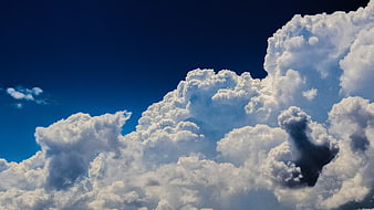 Dramatic Cumulus Clouds Against Deep Blue Sky