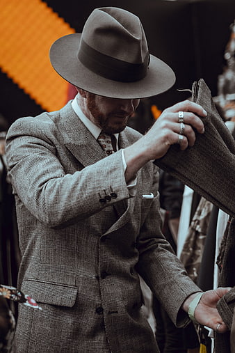 Man in Fedora Hat Examining Plaid Suit Jacket