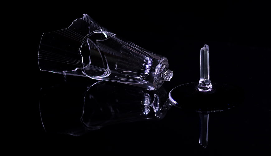 Broken Champagne Glass Shards on Black Reflective Surface