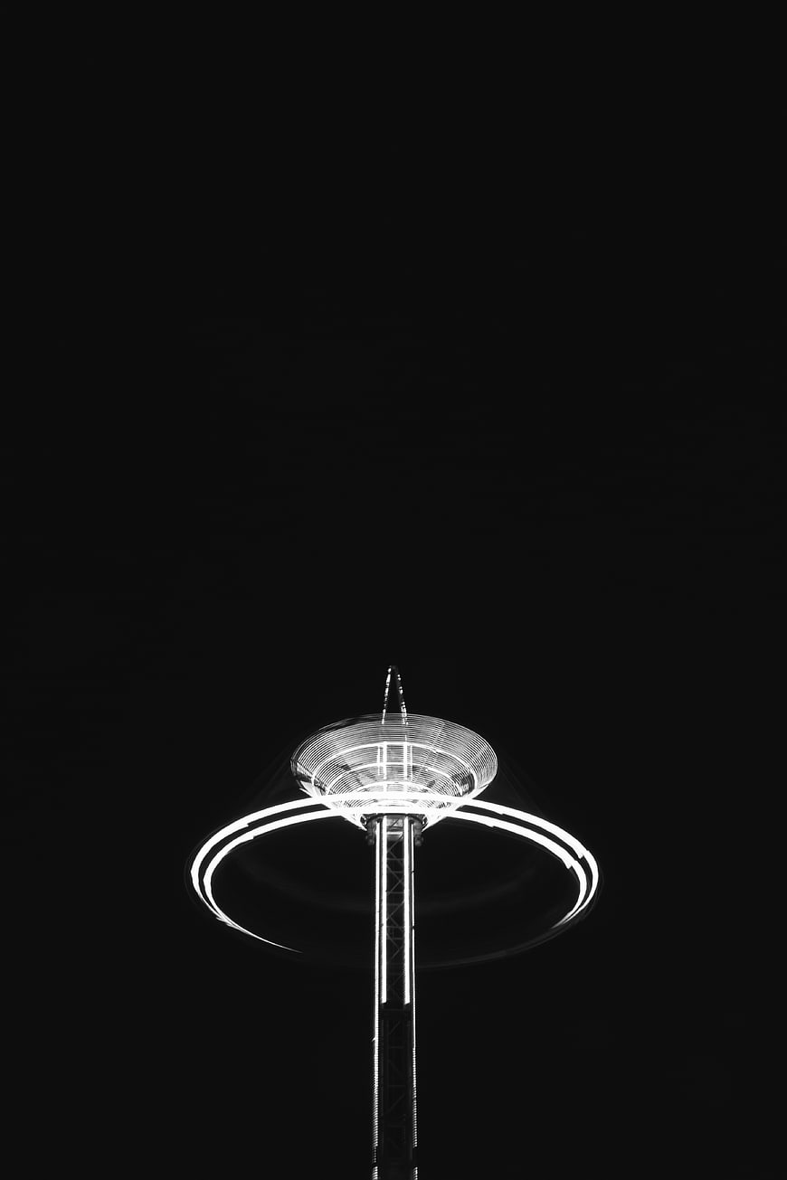 Black and white night photo of illuminated observation tower