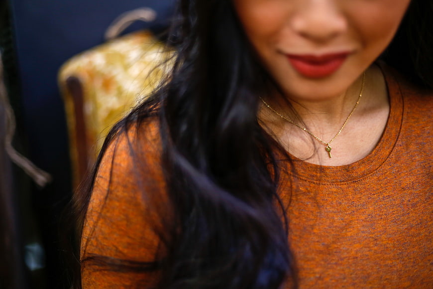 Close-up Portrait of Woman Wearing Gold Key Necklace