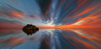 Dramatic Sunset Over Rocky Island with Swirling Sky Reflection