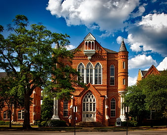 Red Brick Gothic Revival Building with Blue Sky