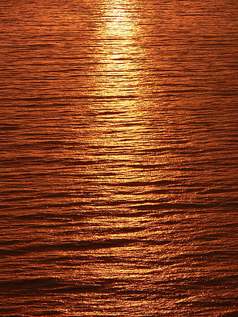 Golden Sunset Reflection on Rippled Ocean Water Surface