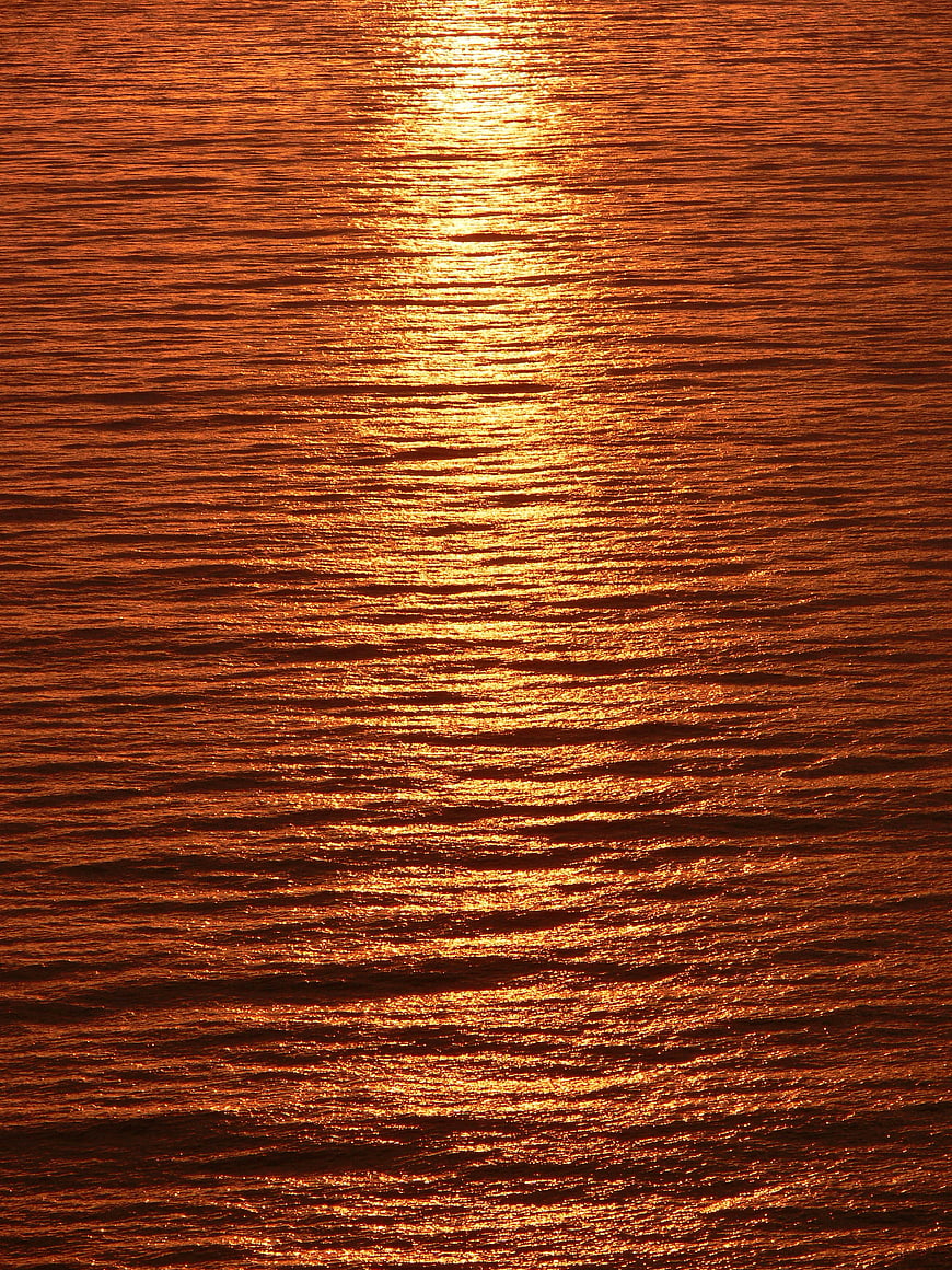 Golden Sunset Reflection on Rippled Ocean Water Surface