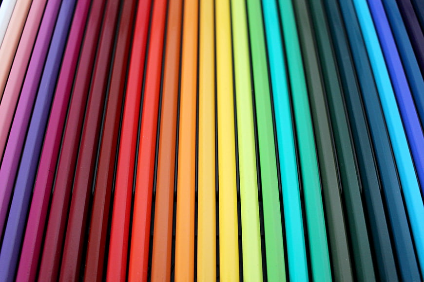 Rainbow colored pencils arranged in a vibrant spectrum