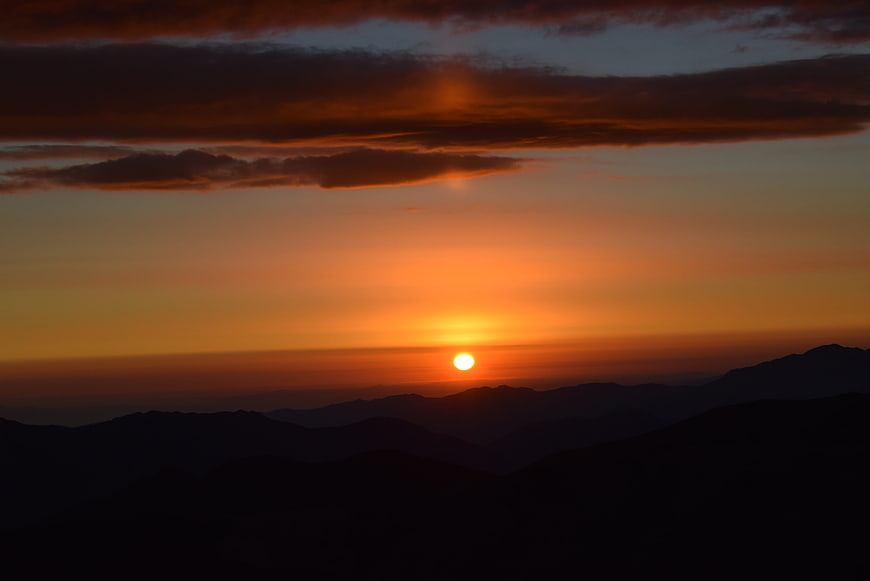 Dramatic Sunset Over Silhouetted Mountain Ranges