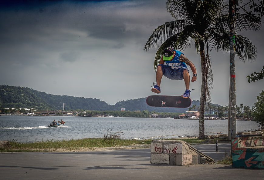 Skateboarder performing aerial trick near waterfront