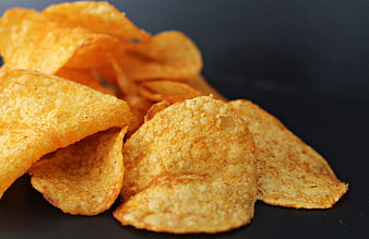 Close-up of seasoned potato chips on dark background
