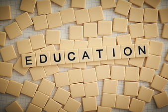 Education spelled with wooden letter tiles on graph paper