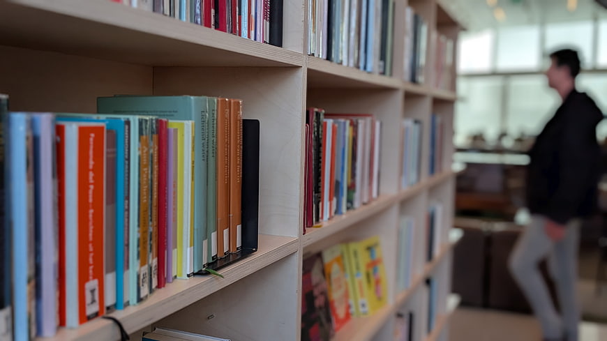 Colorful books on wooden shelves in a modern library
