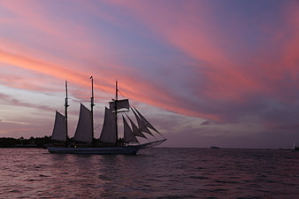 Tall Sailing Ship Silhouette Against Vibrant Pink Sunset Sky