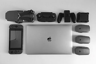 Flat lay of MacBook, Nintendo Switch, and drone accessories