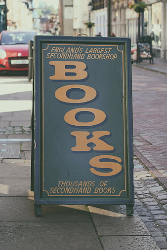 Vintage Secondhand Bookshop Sign on Cobblestone Street