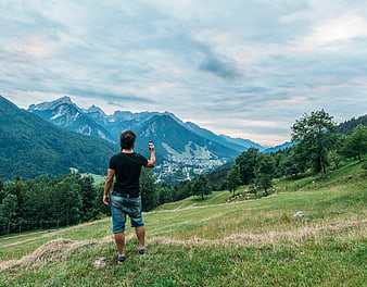 Man Taking Photo of Mountain Landscape with Smartphone