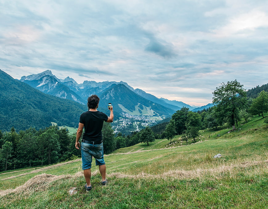 Man Taking Photo of Mountain Landscape with Smartphone