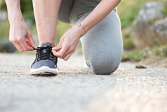 Woman tying running shoe laces outdoors
