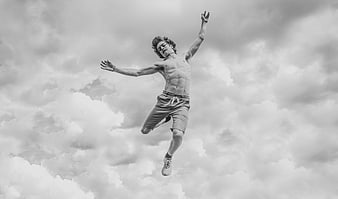 Shirtless Man Jumping High Against Cloudy Sky