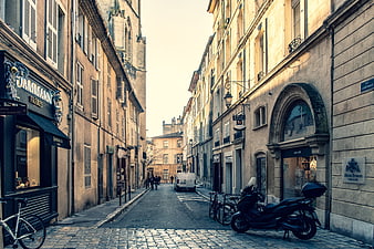 Historic European Street Scene with Cobblestones and Parked Scooter