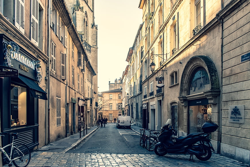 Historic European Street Scene with Cobblestones and Parked Scooter