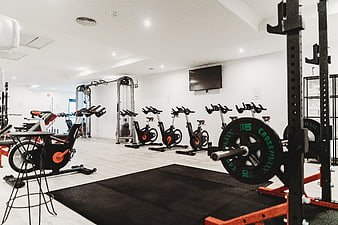 Modern gym interior with exercise bikes and weightlifting equipment