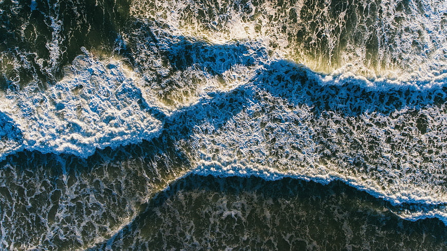 Aerial View of Ocean Waves Crashing on Shore
