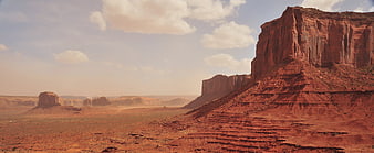 Vast Red Rock Desert Landscape with Buttes and Clouds