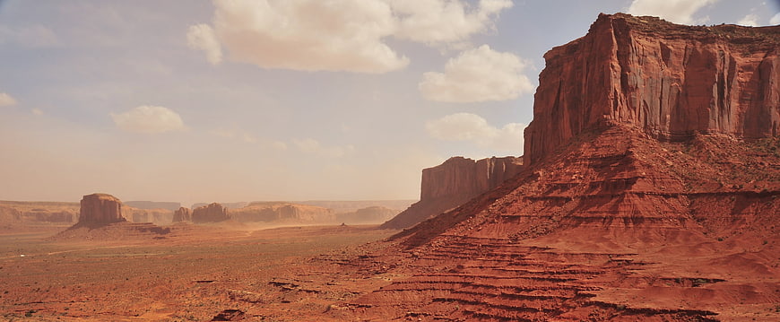 Vast Red Rock Desert Landscape with Buttes and Clouds