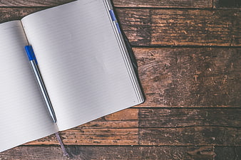 Open Notebook and Pen on Rustic Wooden Table