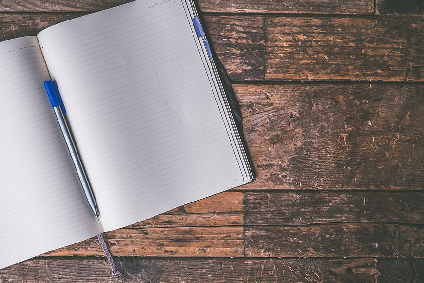 Open Notebook and Pen on Rustic Wooden Table