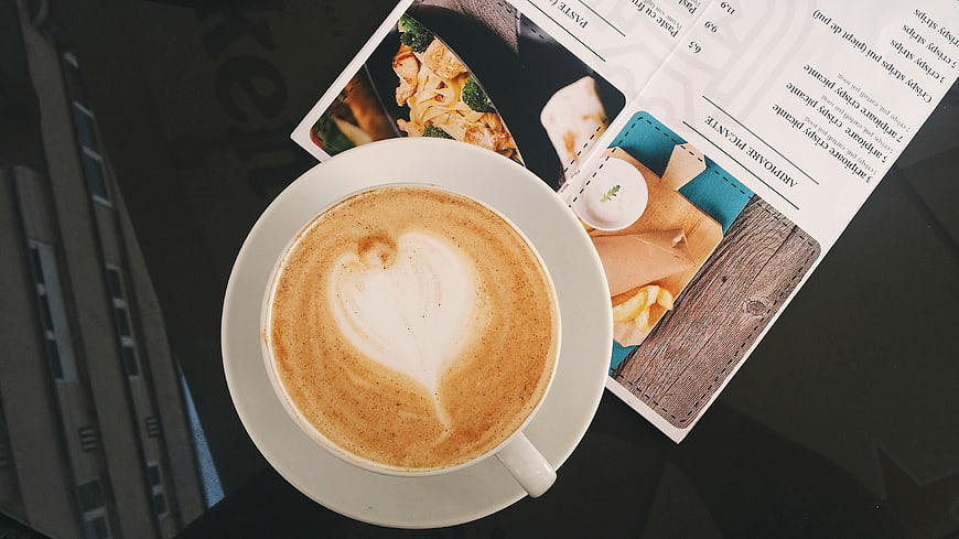 Top View of Cappuccino with Heart Latte Art and Magazine