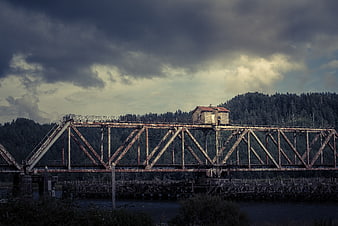 Rusty Truss Bridge with Cabin Over River
