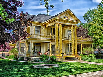 Grand Yellow Victorian House with Columns and Green Lawn