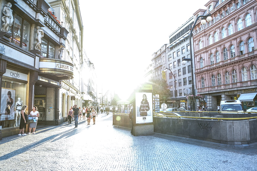 Sunlit Prague Street with Pedestrians and Architecture