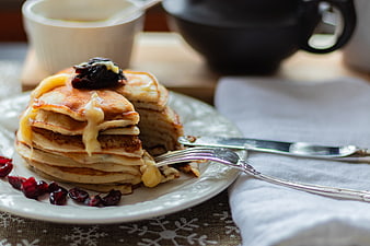 Stack of pancakes with cheese and cranberries on a plate