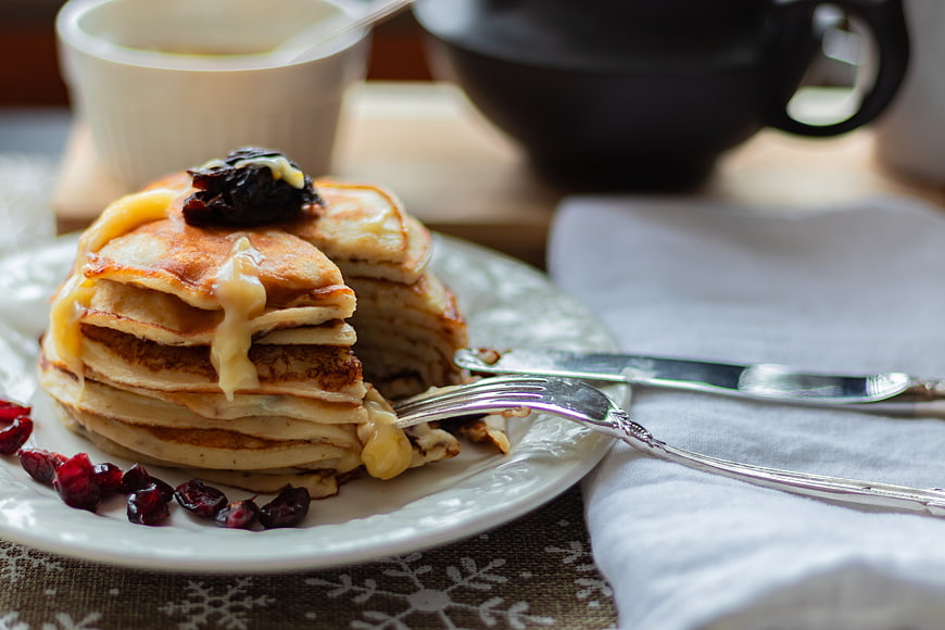 Stack of pancakes with cheese and cranberries on a plate