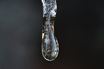 Macro shot of a clear icicle with bubbles on dark background