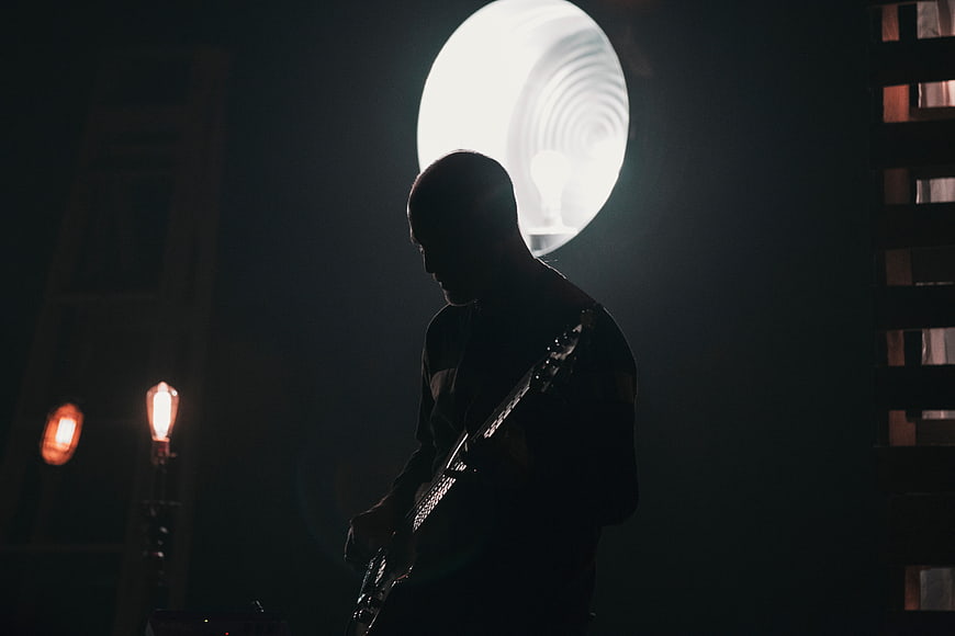 Silhouette of Guitarist Playing in Dark Studio with Backlight