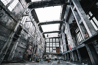Abandoned industrial factory interior with concrete pillars and graffiti