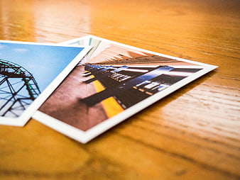 Printed Photographs of Architecture on Wooden Table