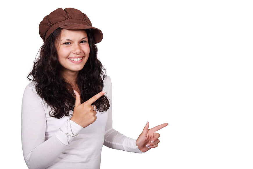 Smiling Woman in Brown Cap Pointing to White Space