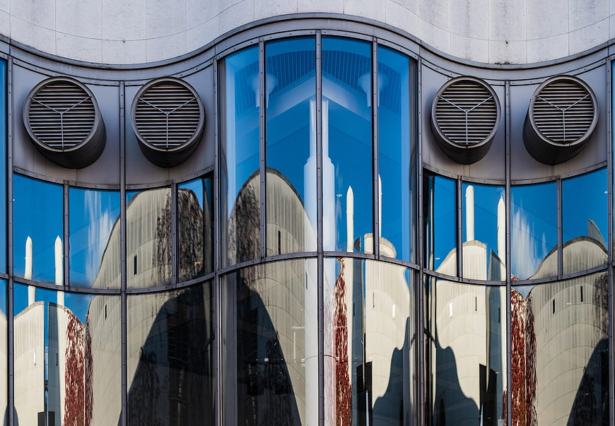 Modern glass building facade with architectural reflections