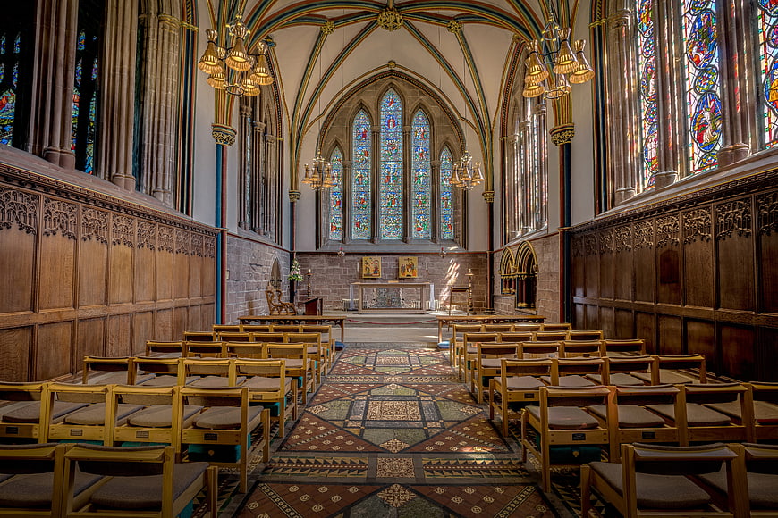 Gothic Church Interior With Stained Glass Windows And Wooden Pews