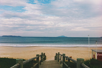 Wooden boardwalk leading to sandy beach with ocean view