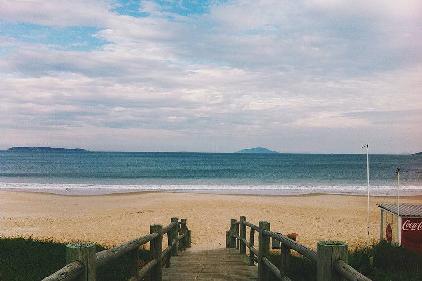 Wooden boardwalk leading to sandy beach with ocean view