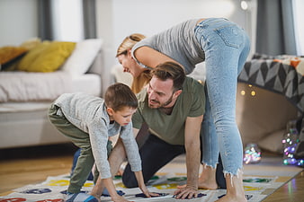 Happy family playing Twister game on living room floor