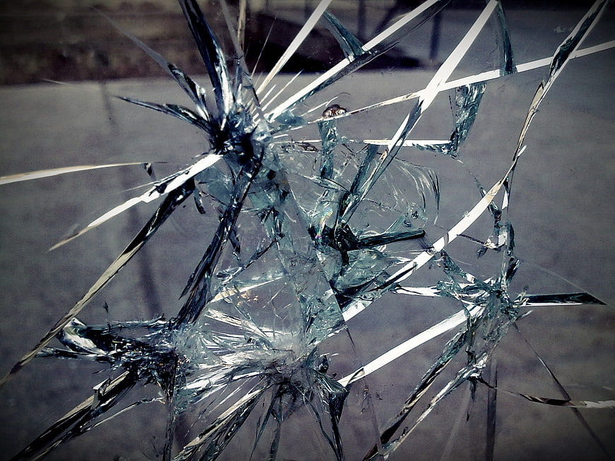Close-up of shattered glass with sharp cracks and splintered edges