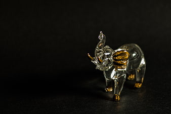Crystal elephant figurine with gold accents on black background