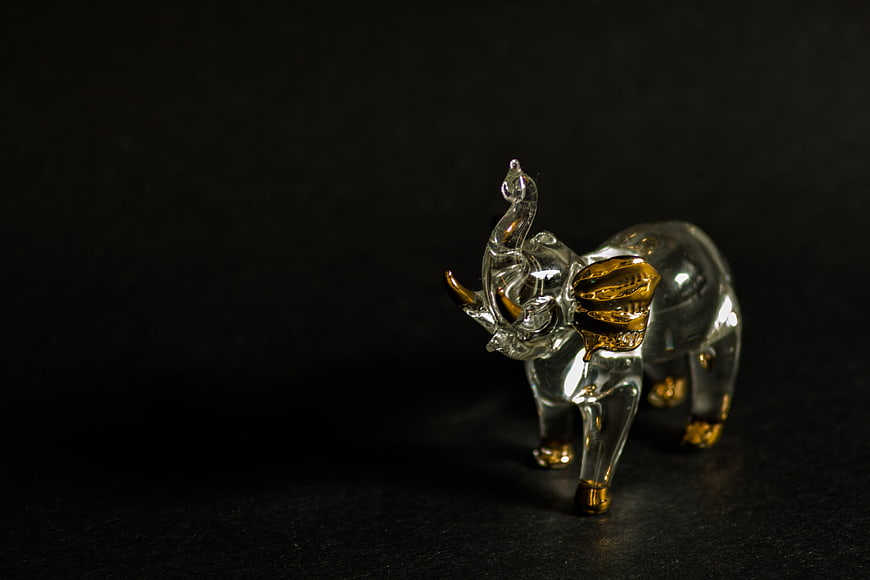Crystal elephant figurine with gold accents on black background